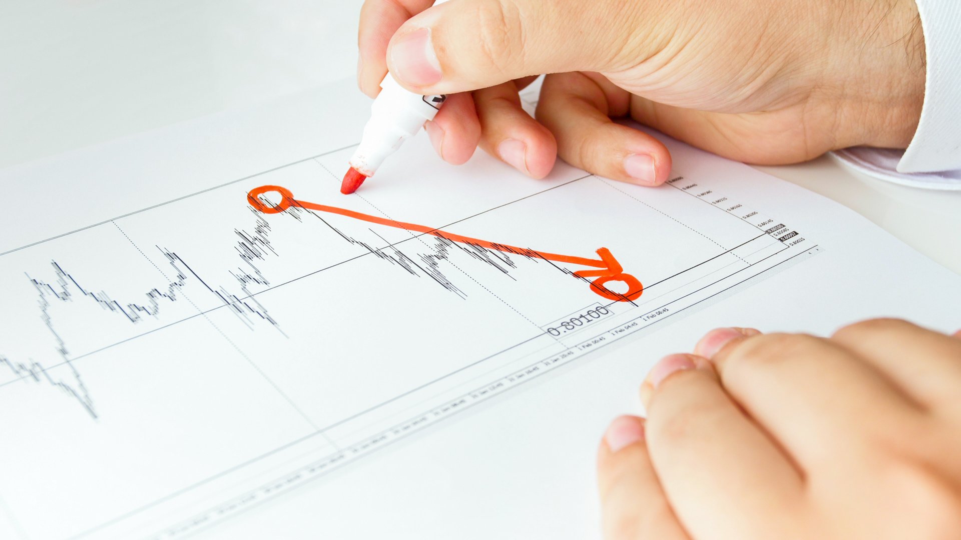 Closeup image of businessman drawing decreasing financial graph